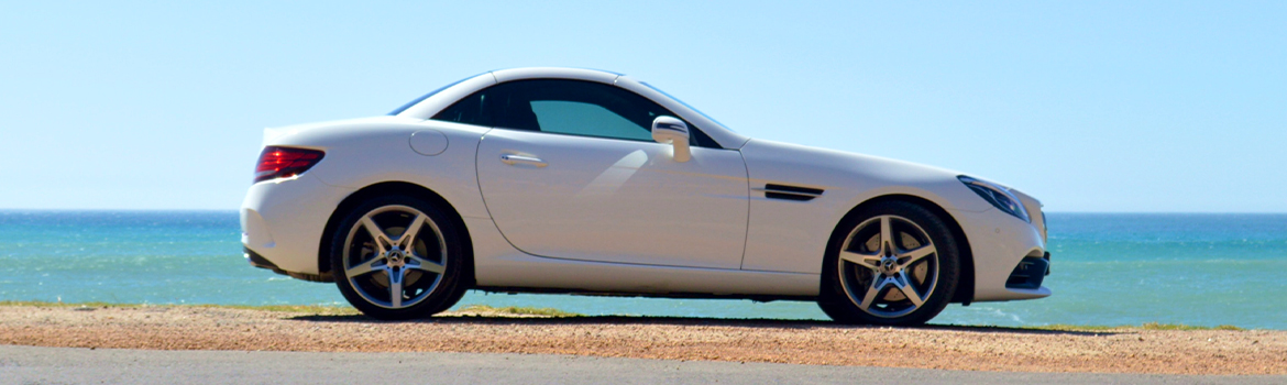 white Mercedes Benz on the beach